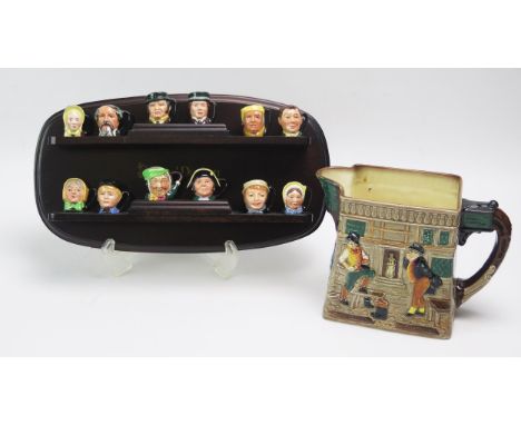 A set of twelve Royal Doulton miniature Dickens character jugs, with polished wood shelf and The white Hart Inn jug.