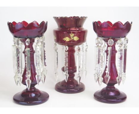 A pair of clear and ruby glass Victorian lusters, with facetted prismatic drops, 32cm high together with a similar single lus