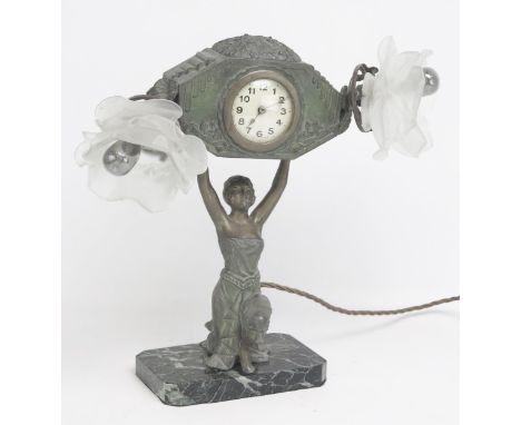 An early 20th century spelter combination mantel clock/ lamp, with 6cm Arabic dial, the clock supported by a kneeling female,