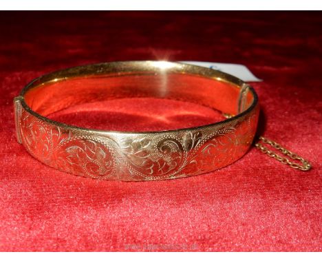 A 9ct gold Bangle with safety chain, by L &amp; Co., 22.06 gms.