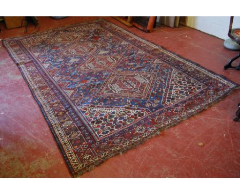 Antique Qashqai carpet, with four lozenges on a indigo field, some wear, 304cm x 210cm.   Condition Report  Fringes incomplet