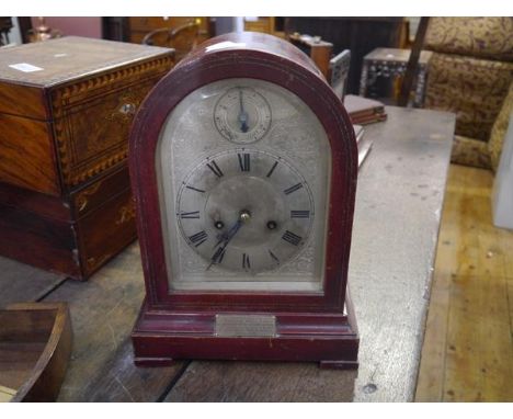 A 1920's mahogany cased mantel clock, of arched form, the silvered dial with Roman numerals and subsidiary dial, bearing pres