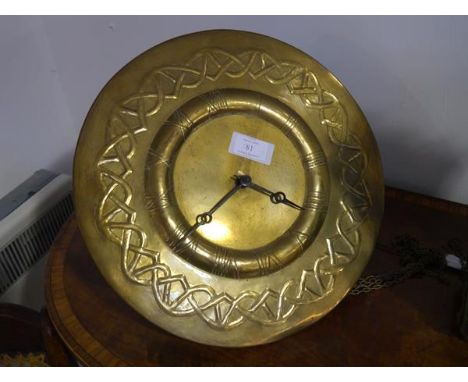 An Art Nouveau brass wall clock, c. 1910,the dial repousse with Roman numerals within a Celtic band, two train movement strik