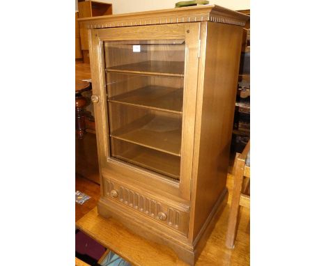 A contemporary Ercol mid-elm hi-fi cabinet, having a hinged top, glazed door, and lower drawer, w.56cm