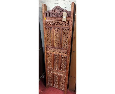 *A contemporary Indonesian relief carved and pierced teak four-fold dressing screen, each panel width 51.5cm