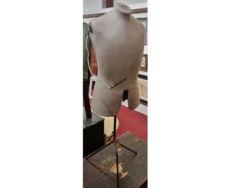 An early 20th century shop display mannequin, fabric clad, and raised on enamelled metal rodded triform base, height 133cm