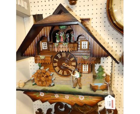 *A contemporary carved wood Swiss cuckoo wall clock, with three weights