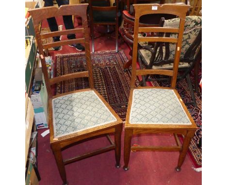A pair of Arts &amp; Crafts oak ladder back dining chairs, each having stylised green fabric floral upholstered pad seats on 