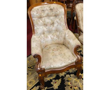 A mid-Victorian oak framed scroll armchair, having silk needlework floral button back upholstery with all over further scroll