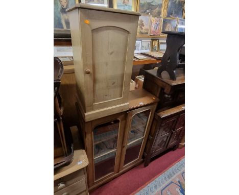 A rustic pine low double door glazed bookcase, w.82cm; together with a Victorian stripped pine single door bedside cupboard, 