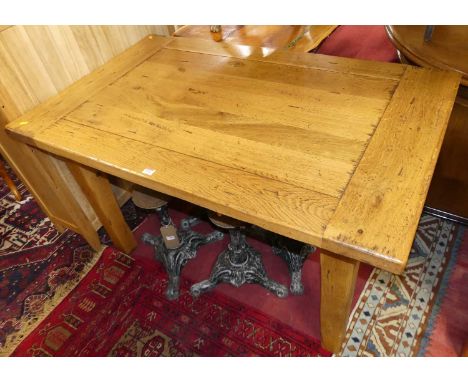 A contemporary joined light oak rectangular dining table, having cleated ends and raised on square block supports, length 130