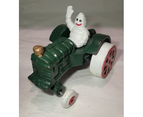Cast iron Michelin Man on a tractor, H: 10 cm. P&amp;P Group 1 (£14+VAT for the first lot and £1+VAT for subsequent lots) 