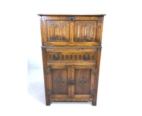 Oak linen fold drinks cabinet with mirrored interior and drawer and cupboards below, lemon squeezer thrown in, approx 74cm x 