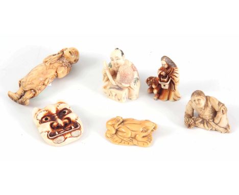 A COLLECTION OF SIX MEIJI PERIOD JAPANESE IVORY NETSUKE three with various figures, a mask and frogs, four having character m