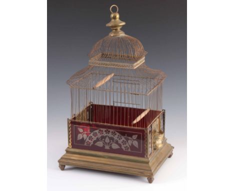 A VICTORIAN BRASS AND CRANBERRY GLASS BIRDCAGE having a brass finial above a pagoda style frame on moulded base 55cm high