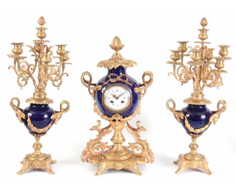 A LATE 19TH CENTURY FRENCH ORMOLU AND PORCELAIN CLOCK GARNITURE the blue porcelain case with ormolu pineapple finial supporte