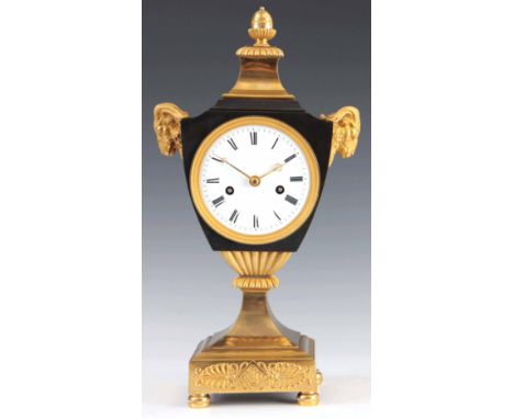 AN EARLY FRENCH BRONZE AND ORMOLU URN SHAPED MANTEL CLOCK the patinated case flanked by two gilt rams heads and surmounted by