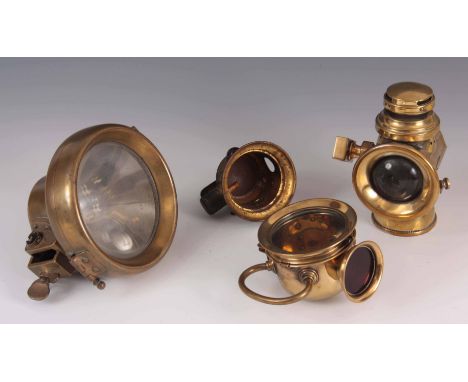 A SELECTION OF FOUR VINTAGE BRASS CAR LAMPS to include a 'DESMO' lamp, a rear lamp with red glass and loop handle, a 'CAV' mo