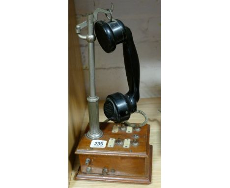 An old stick telephone on mahogany base