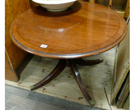 Circular reproduction mahogany coffee table on pillar base with four brass feet 