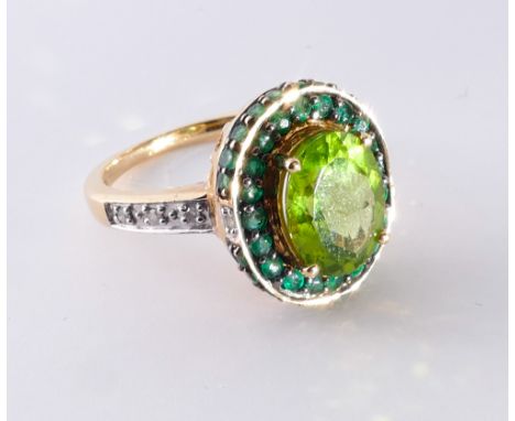 Unusual peridot, emerald and diamond dress ring, set with a large oval peridot surrounded by emeralds, on diamond shoulders s