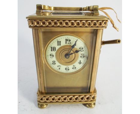 Porcelain faced brass carriage clock with curb chain style decoration with key - measures 11.5cm tall