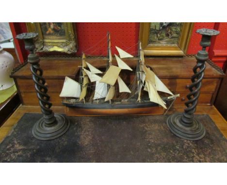 A pair of barley twist candlesticks and a model boat