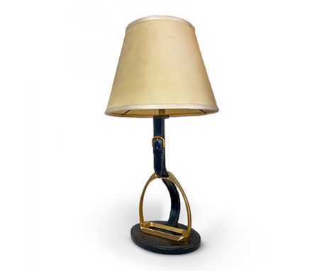 JACQUES ADNET (France, 1900-1984).Table lamp "Stirrup".In black leather and brass. Parchment shade.Working electrical system.