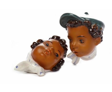 PAIR OF AUSTRIAN WALL PLAQUESmodelled as a woman in a blue and white head scarf, and a boy in a cap with matching necktie, ap