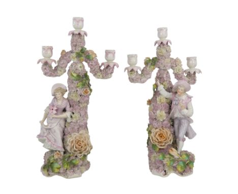 A pair of late 19th century Meissen style three branch candlesticks - flower encrusted and modelled with male and female figu