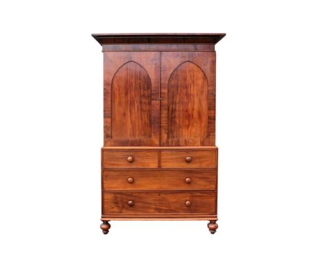A late George III mahogany linen press - the moulded cornice above a pair of lancet panel doors enclosing slides, the base wi