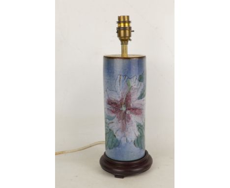 A cylindrical ceramic table lamp - decorated with flowers on a blue ground, 34cm high.