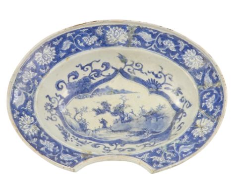 A 19th century chinoiserie bleeding/barber's bowl - blue and white decorated with a landscape scene showing a figure on a bri