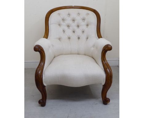 A late Victorian mahogany showwood framed spoonback chair with enclosed arms, part button upholstered in biscuit coloured fab