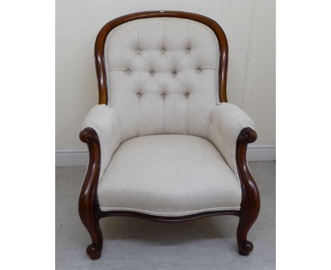 A late Victorian mahogany showwood framed spoonback chair with enclosed arms, part button upholstered in biscuit coloured fab