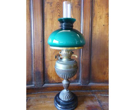 Unusual oil lamp with Twin Duplex burner on a Trophy style brass column with black circular stepped base. Dark green glass sh