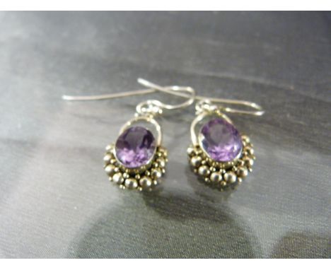 Pair of Amethyst earrings set in silver with balled decoration around the stone Total approx weight 6.3g