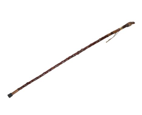 A novelty wooden walking stick. The handle carved as a parrot with glass eyes, perched on a trunk, having a brass collar, L14