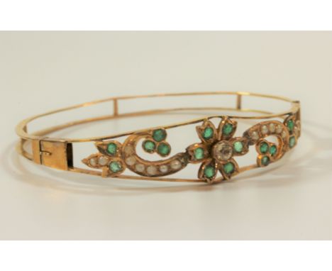 An 18 carat gold emerald, seed pearl and possibly white sapphire bangle (lots of damaged/broken stones) 