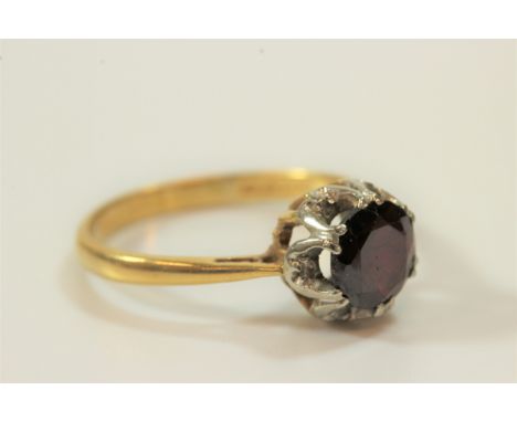 An 18 carat gold garnet and diamond cluster ring 