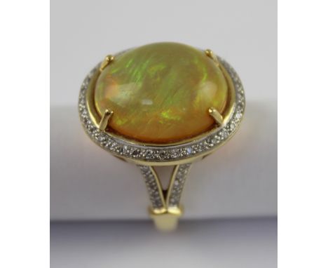 An 18ct yellow gold ladies' dress ring set with a large Welo opal and small diamond surround, size N, approx 10.3g. CONDITION