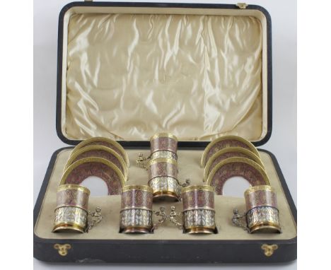 A cased set of Limoges demitasse coffee cans with hallmarked silver cradles, comprising six cups and six saucers, pink and pu