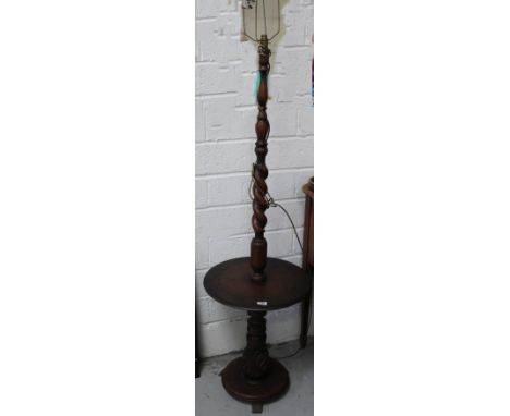 An early 20th century mahogany standard lamp, wrythen column to circular table top above a turned and carved support, to circ