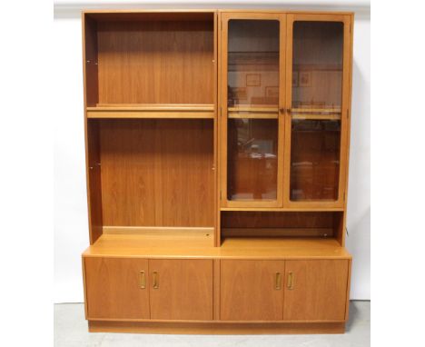 A G-Plan lounge unit with an open shelf bookcase and a glazed cabinet surmounting a four-cupboard base, with a matching corne