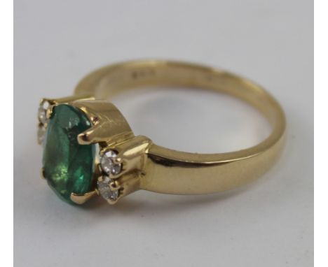 A 14ct gold emerald and chip diamond dress ring, the central stone measuring approx 7 x 10mm across the table, size R, approx