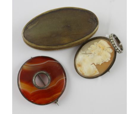 A red and orange agate gilt brooch, a shell cameo in pinchbeck mount, a silver seed pearl solitaire and a horn snuff box (4).