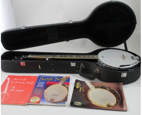 A cased Stagg five-string bluegrass banjo with two associated music books (3).