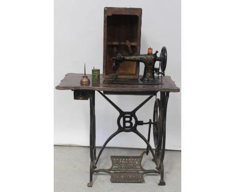 An early 20th century Singer treadle sewing machine, an associated manual and two small vintage oil cans.
