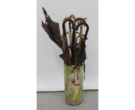 An Art Nouveau style figural decorated stick stand containing a quantity of vintage umbrellas to include a 1960s example with