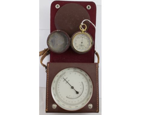 A small burgundy leather cased brass pocket barometer by E B Meyrowitz Inc, New York, London and Paris, this example made in 